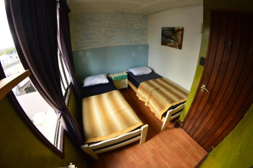 2 camas en una habitación pequeña con ventana en Torre al Sur en Ushuaia