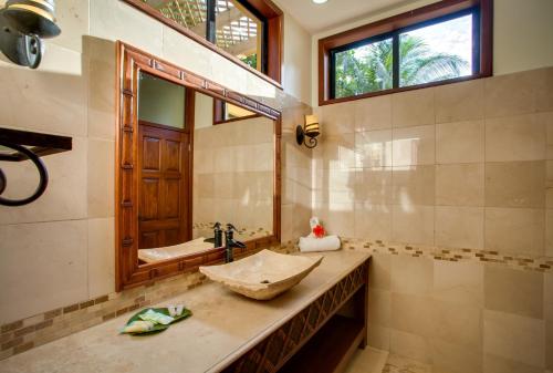a bathroom with a sink and a mirror at Villa Margarita at Jaguar Reef in Hopkins