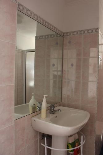 a bathroom with a sink and a mirror at Casa dos Caseiros in Santa Cruz