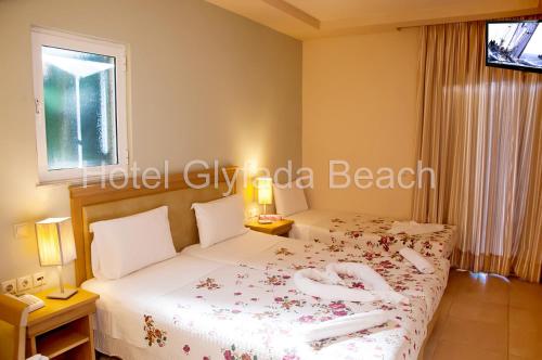 a hotel room with two beds and a window at Glyfada Beach Hotel in Glyfada