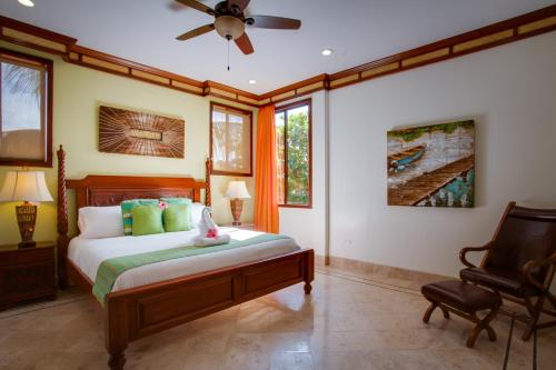 a bedroom with a bed and a ceiling fan at Villa Margarita at Jaguar Reef in Hopkins