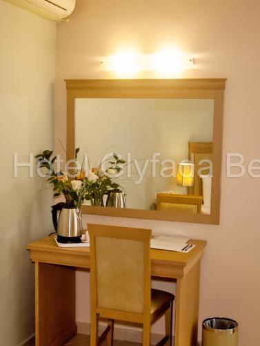 a vanity with a mirror and a table with a chair at Glyfada Beach Hotel in Glyfada