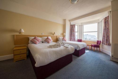 ein Hotelzimmer mit 2 Betten und einem Fenster in der Unterkunft Bayshore Hotel in Sandown