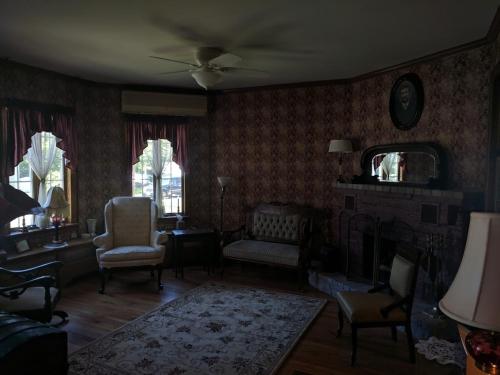 a living room with chairs and a table and a mirror at Inn at the Park in Cape May
