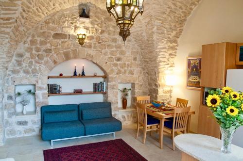 ein Wohnzimmer mit einem blauen Sofa und einem Tisch in der Unterkunft Artist Quarter Guesthouse B&B in Safed