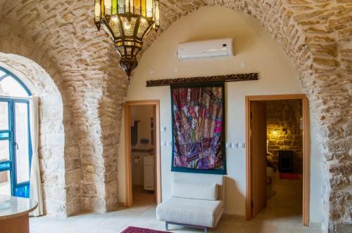 a room with an archway with a chair and a painting on the wall at Artist Quarter Guesthouse B&B in Safed