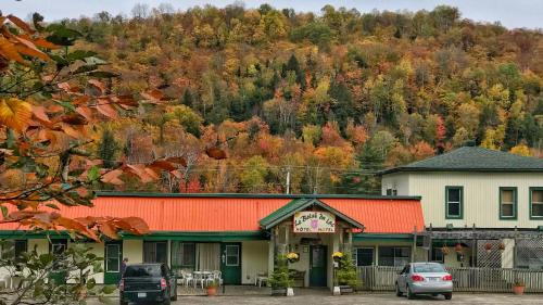 um edifício com um telhado laranja em frente a uma montanha em Le Boisé du Lac em Mont-Tremblant