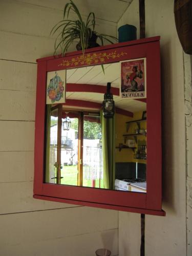 uno specchio rosso sul lato di una parete di Roulotte coin de nature a Lannion