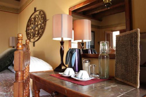 a bedroom with a table with two lamps and a bed at Hotel El Real in Real de Catorce
