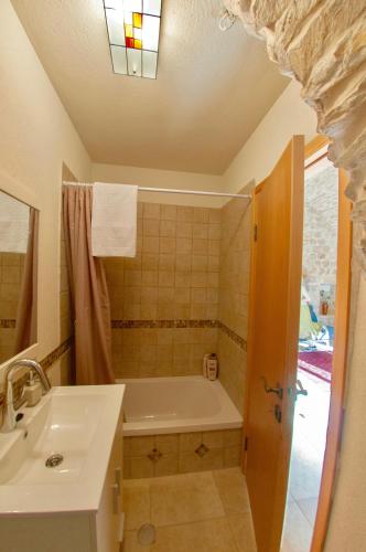 a bathroom with a bath tub and a sink at Artist Quarter Guesthouse B&B in Safed