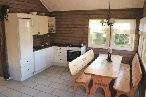 a kitchen with a wooden table and a table and a table and chairs at Cabin by the river in Storslett