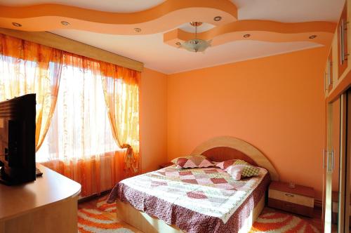 una camera da letto con pareti arancioni e un letto di fronte a una finestra di Stephanie Apartment a Braşov