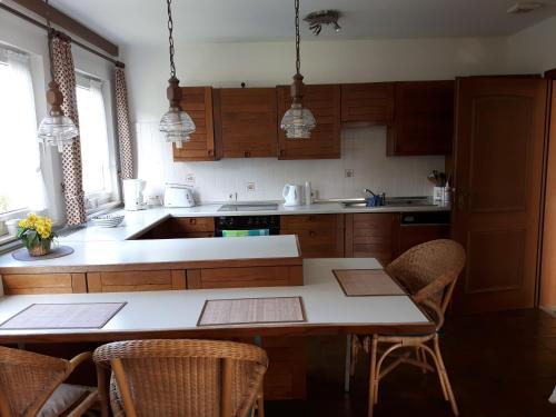 オルスベルクにあるFerienwohnung Grothoffのキッチン(木製キャビネット、テーブル、椅子付)