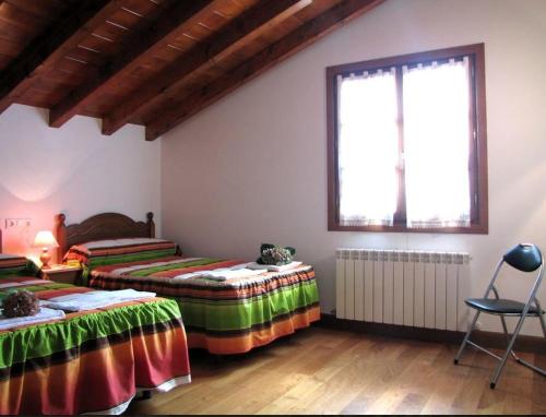 1 dormitorio con 2 camas y ventana en Casa Bentta, en Errazu