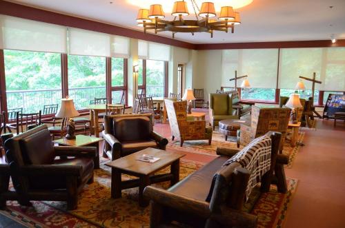 a hotel lobby with chairs and tables and windows at Overlook Lodge and Stone Cottages at Bear Mountain in Highland Falls