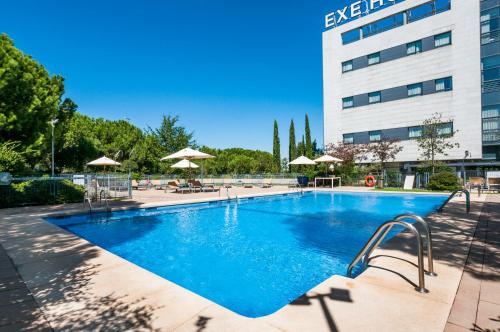 a large swimming pool in front of a building at Exe Madrid Norte in Madrid