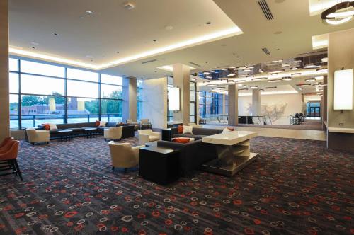 a lobby with couches and tables in a building at The Hotel at the University of Maryland in College Park