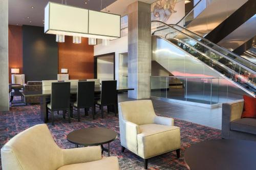 a lobby with a table and chairs and stairs at The Hotel at the University of Maryland in College Park