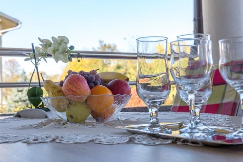 a bowl of fruit on a table with wine glasses at Apartment Snježana in Slunj