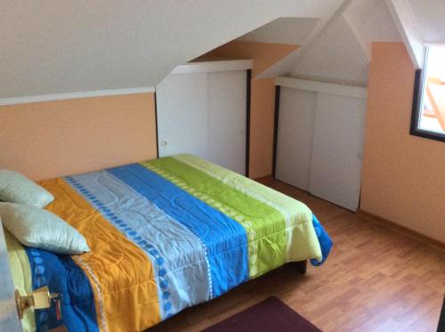 a bedroom with a bed with a colorful blanket at Hostal Brisas del Sur in Temuco