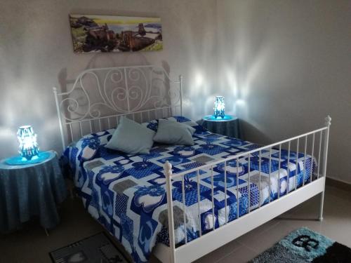 a bedroom with a bed with a blue and white comforter at La Casa del Professore in Santa Teresa di Riva