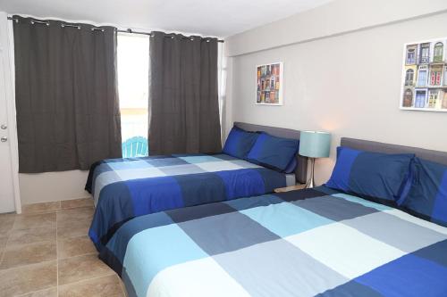 two beds in a bedroom with blue and white at Daytona Beach Club Studios! in Daytona Beach
