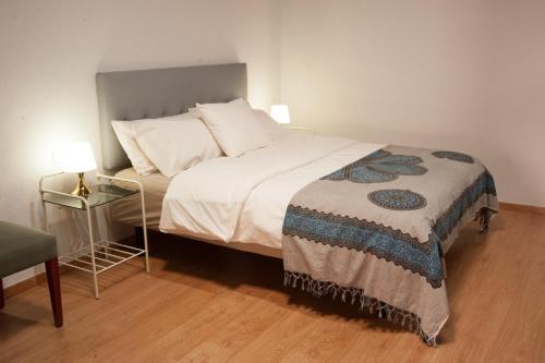 a bedroom with a bed and a table with a lamp at Varanski Vista in San Miguel de Abona