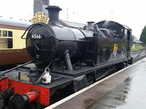 a black train is sitting on the tracks at Pine Tree Lodge, Bridgnorth in Bridgnorth