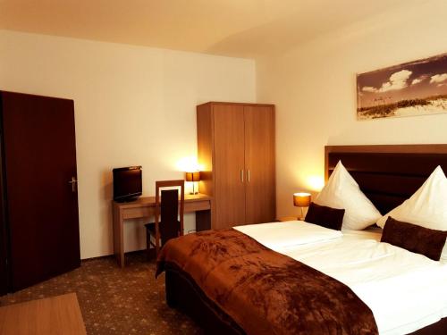 Pokój hotelowy z łóżkiem i biurkiem w obiekcie Hotel Dormir w mieście Moers
