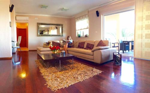 a woman sitting on a couch in a living room at Villa Marija in Marina