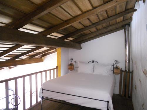 1 Schlafzimmer mit einem weißen Bett auf einem Balkon in der Unterkunft Encosta do Castelo in Portel
