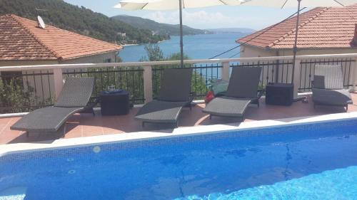 a group of chairs sitting next to a swimming pool at Villa Marija in Marina