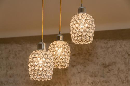 a group of three lights hanging from a ceiling at Apartment Joanneum in Graz