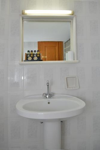 a white sink in a bathroom with a mirror at Theoni Studios in Kastraki Naxou