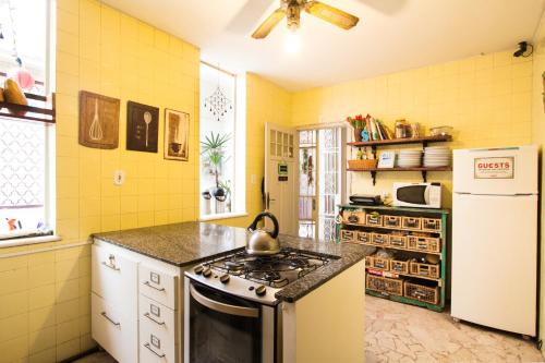 a yellow kitchen with a stove and a refrigerator at Discovery Hostel in Rio de Janeiro