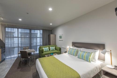 a bedroom with a large bed and a large window at Quest Atrium Serviced Apartments in Wellington