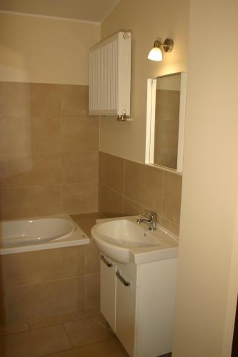 a bathroom with a sink and a bath tub at Noclegi Piastow in Piastów