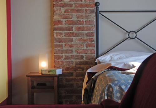 a bedroom with a bed and a brick wall at Agriturismo la Sforzata in Collegno