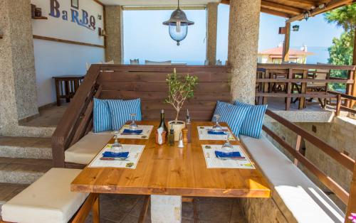 Spiros-Soula Family Hotel & Apartments في أغيا بيلاغيا: طاولة وكراسي خشبية على الفناء