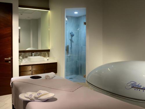 a bathroom with a tub and a sink and a shower at HS HOTSSON Hotel Irapuato in Irapuato