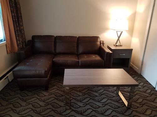 a living room with a couch and a coffee table at Holiday Motel & RV Resort in Hope