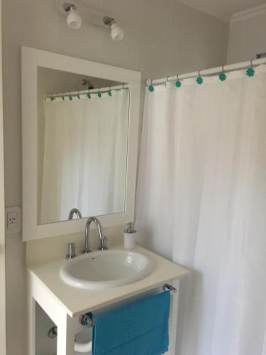 y baño con lavabo, espejo y cortina de ducha. en Septiembre, en Colón