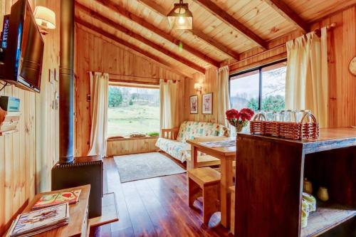 a living room with a table and a couch at Murmullo de Arroyos in Caburgua