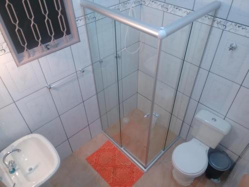 y baño con ducha, aseo y lavamanos. en Pousada Deus é Fiel, en Cachoeira Paulista