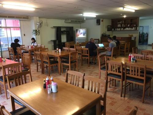 a restaurant with wooden tables and people sitting at tables at The Residence Hotel -SHA Extra Plus in Chiang Mai