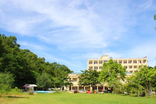 a building with a park in front of it at Hanvet Hotel Do Son in Ðố Sơn