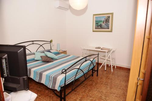 a bedroom with a bed and a table with a desk at Affittacamere Fiorella in Riomaggiore
