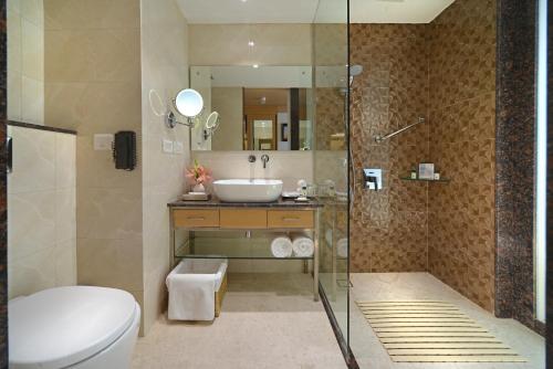 ein Bad mit einem WC, einem Waschbecken und einer Dusche in der Unterkunft Fortune Inn Promenade, Vadodara - Member ITC's Hotel Group in Vadodara