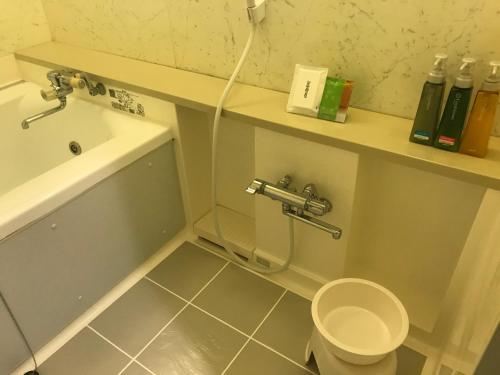 a bathroom with a toilet and a sink and a tub at Hotel Vegas (Adult Only) in Sapporo