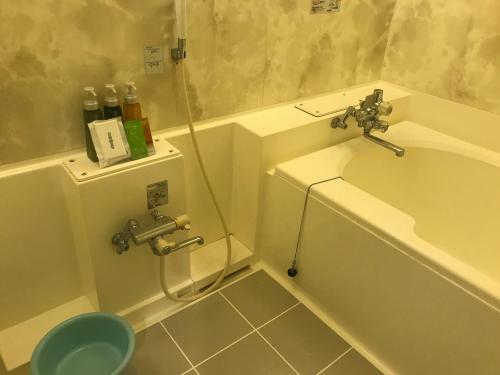 a bathroom with a tub and a toilet and a sink at Hotel Vegas (Adult Only) in Sapporo